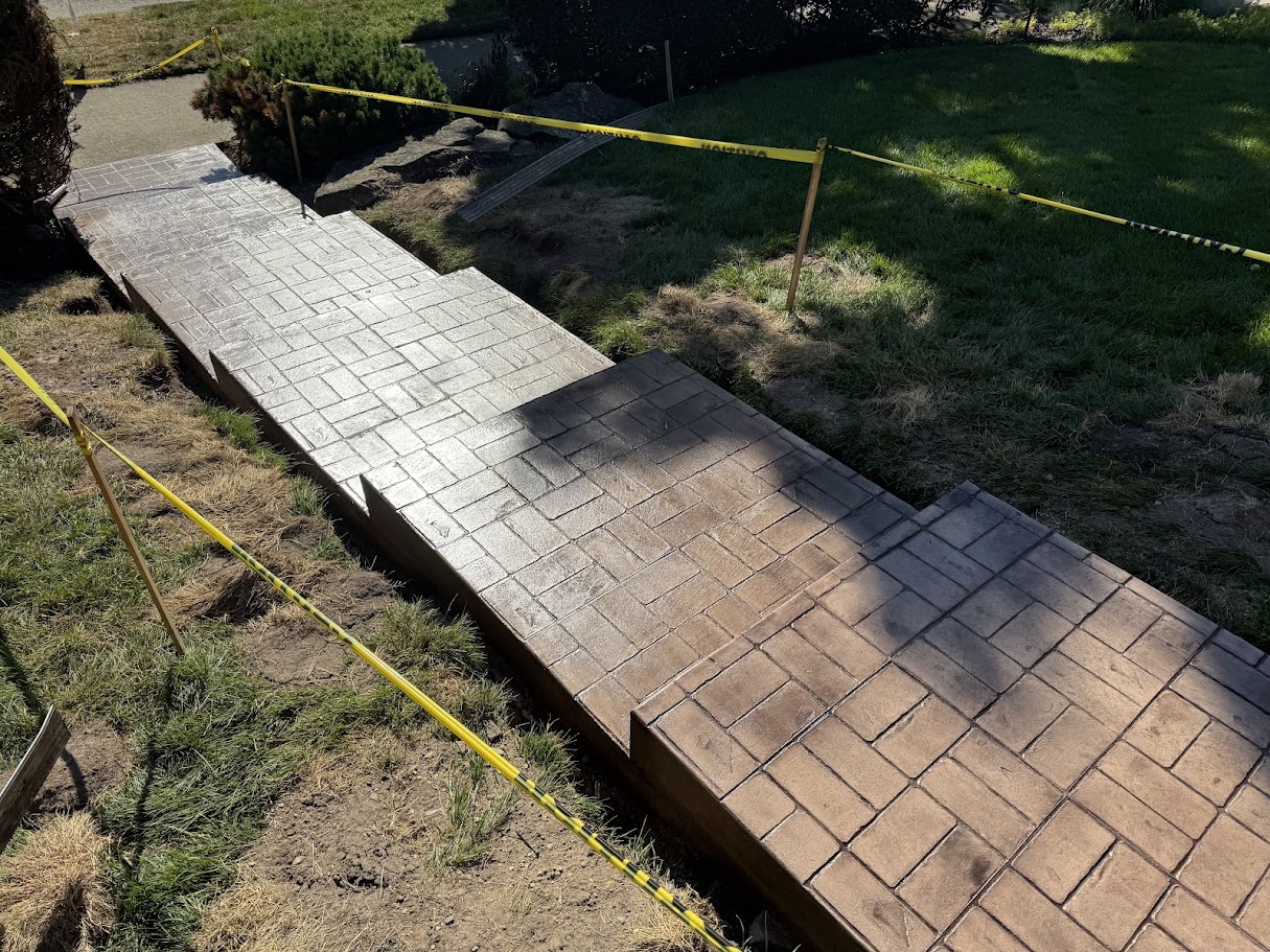 freshly installed stamped concrete walkway roped off with caution tape during curing process