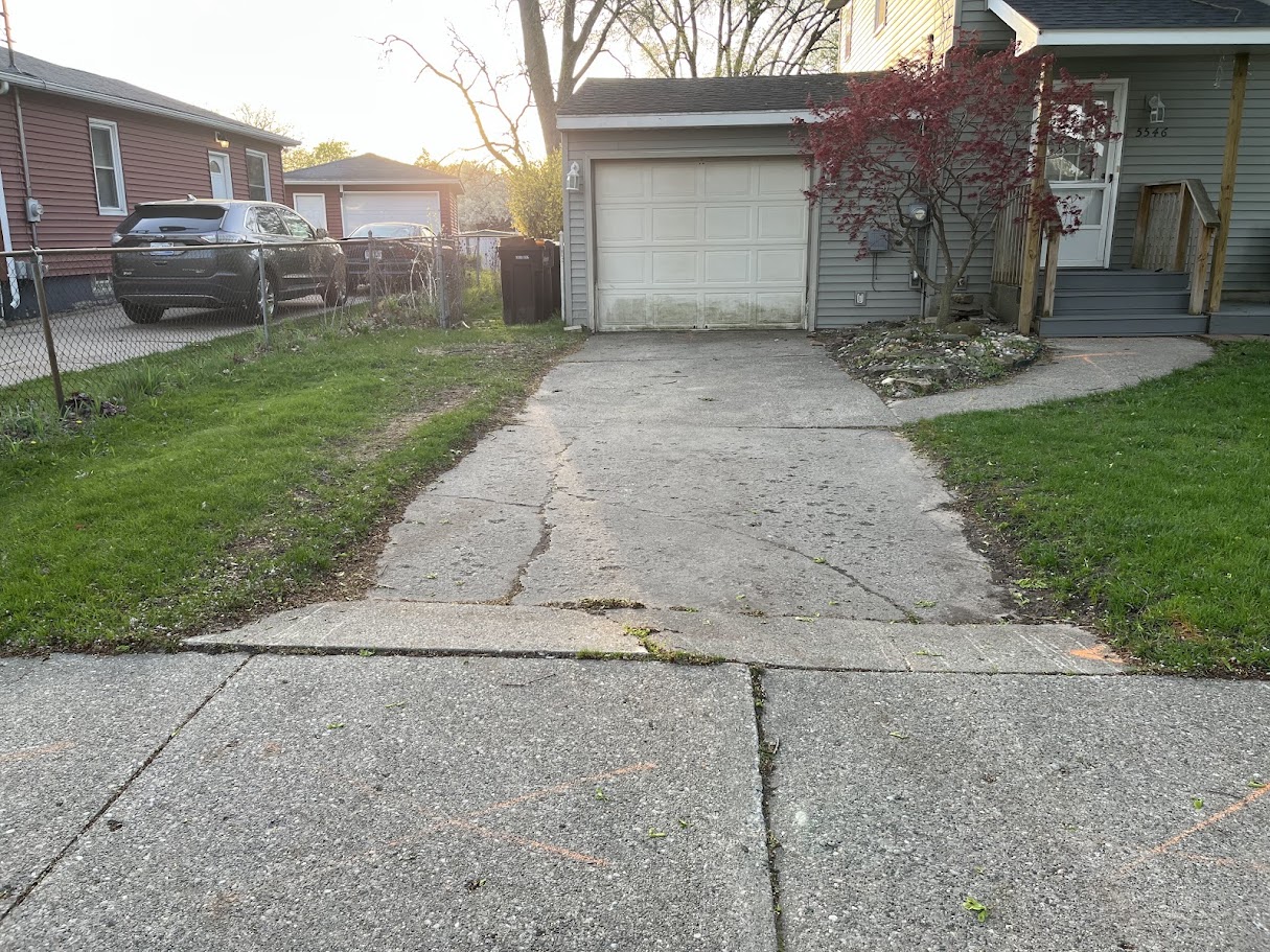 Old cracked concrete driveway before replacement at a Michigan home