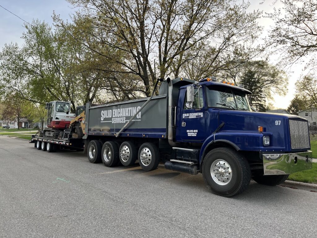 Solid Excavating's excavation truck and equipment arriving on-site for concrete driveway removal