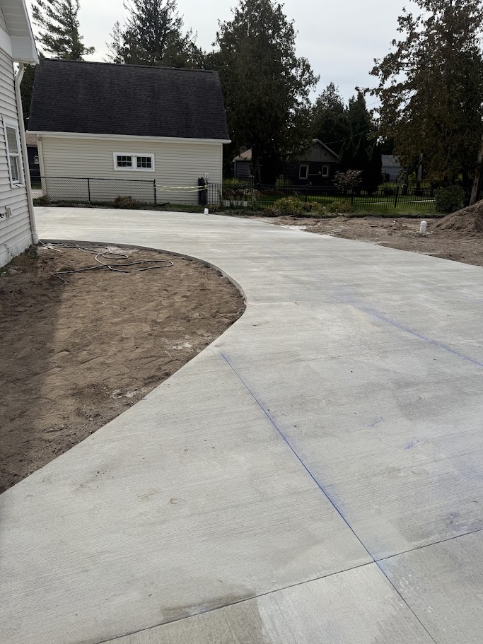 Curved concrete driveway installation at a modern cottage with clean edgework