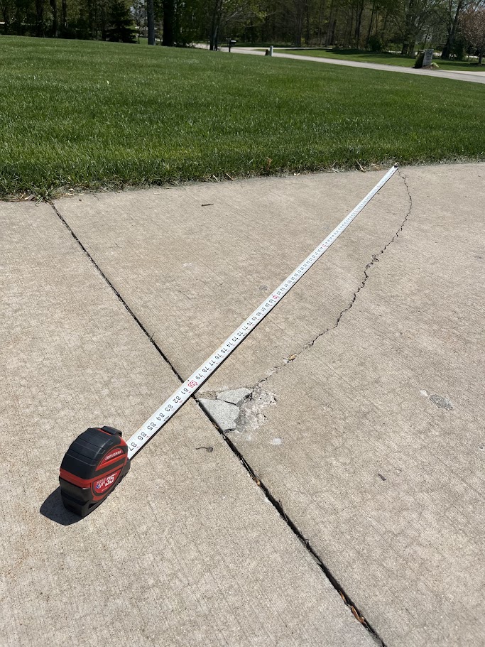 Measuring a crack in a concrete slab during a professional concrete evaluation