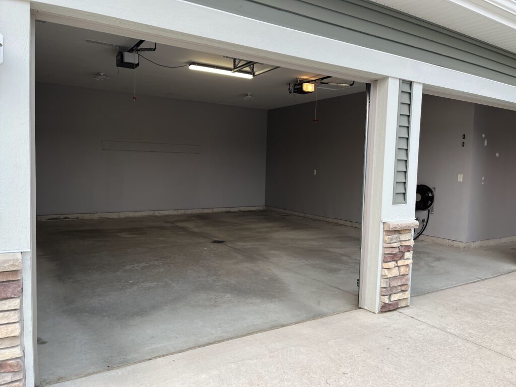 Before garage floor coating installation showing a worn and stained concrete garage floor