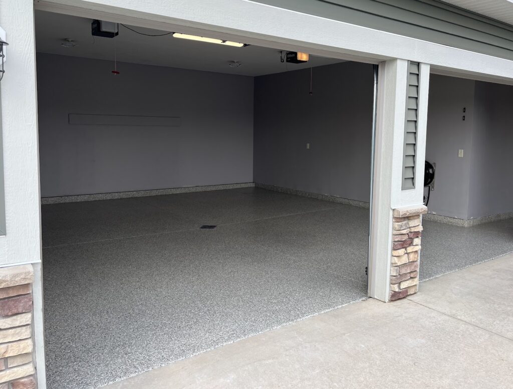Garage floor after coating installation with a clean speckled finish